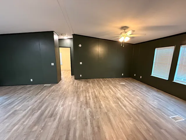 wooden floor in an empty room with a chandelier