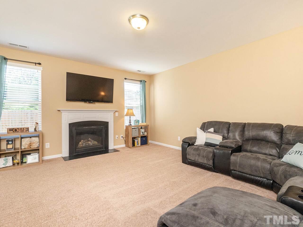 204 Hope Valley Road Knightdale, NC 27545 - Photo 13 of 30 a living room with furniture a flat screen tv and a fireplace