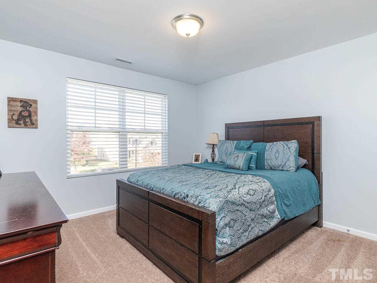 204 Hope Valley Road Knightdale, NC 27545 - Photo 18 of 30 a bed sitting in a bedroom next to a window