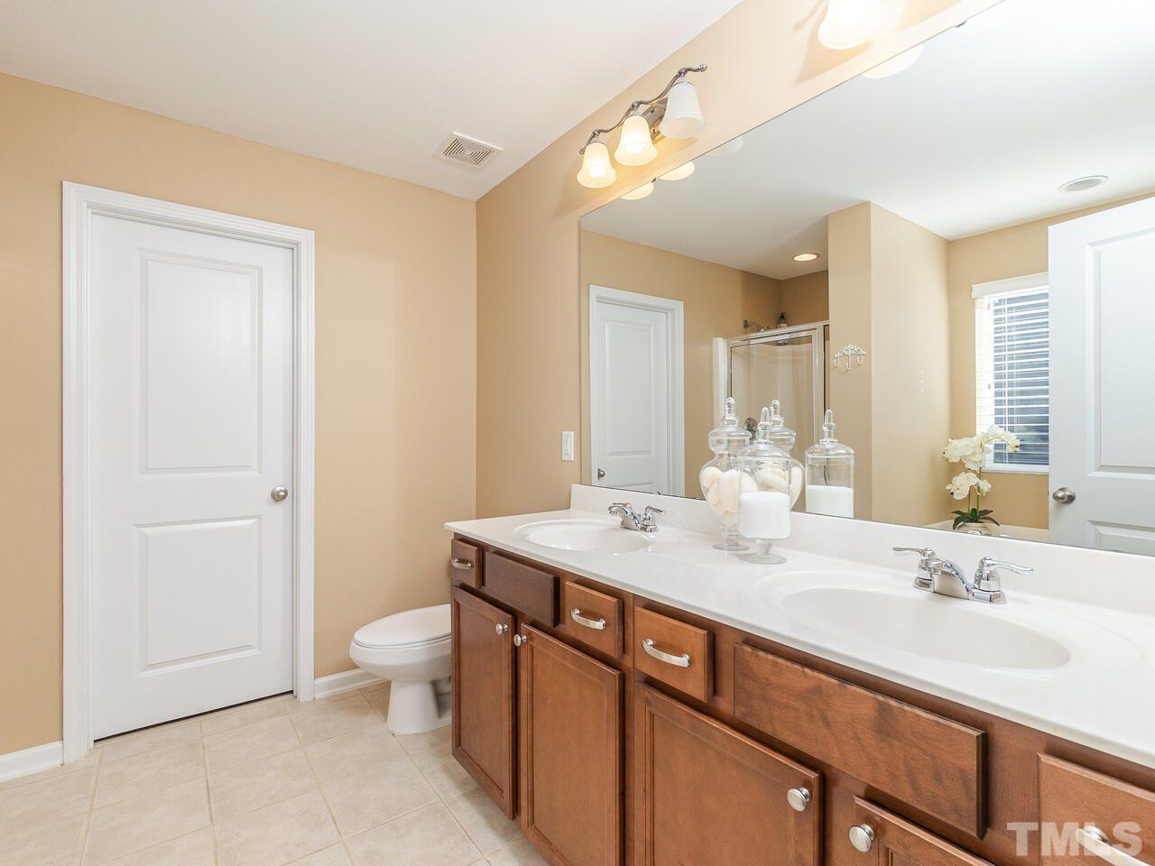204 Hope Valley Road Knightdale, NC 27545 - Photo 22 of 30 a bathroom with a sink a toilet and a large mirror