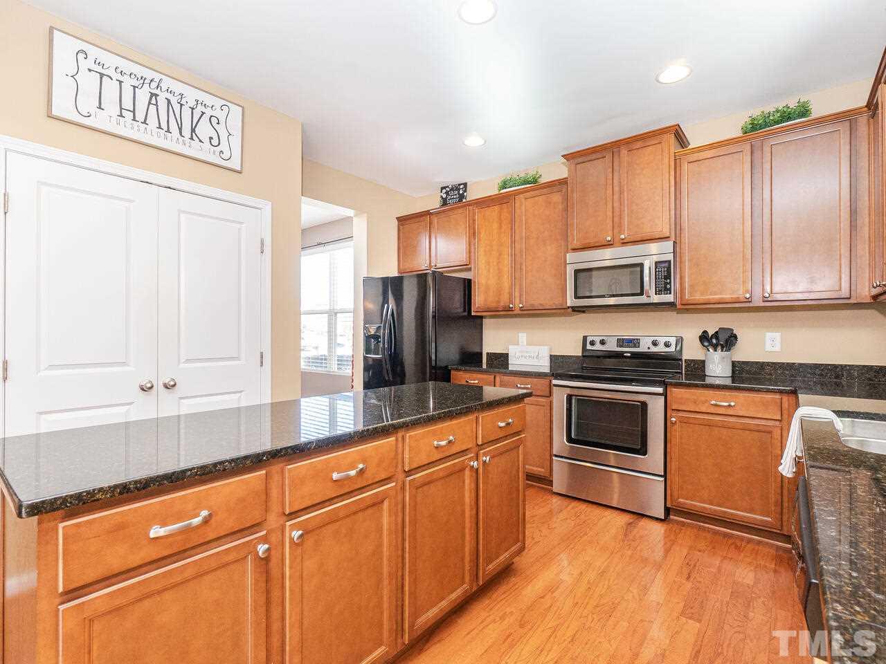 204 Hope Valley Road Knightdale, NC 27545 - Photo 7 of 30 a kitchen with stainless steel appliances granite countertop a stove a sink and a refrigerator