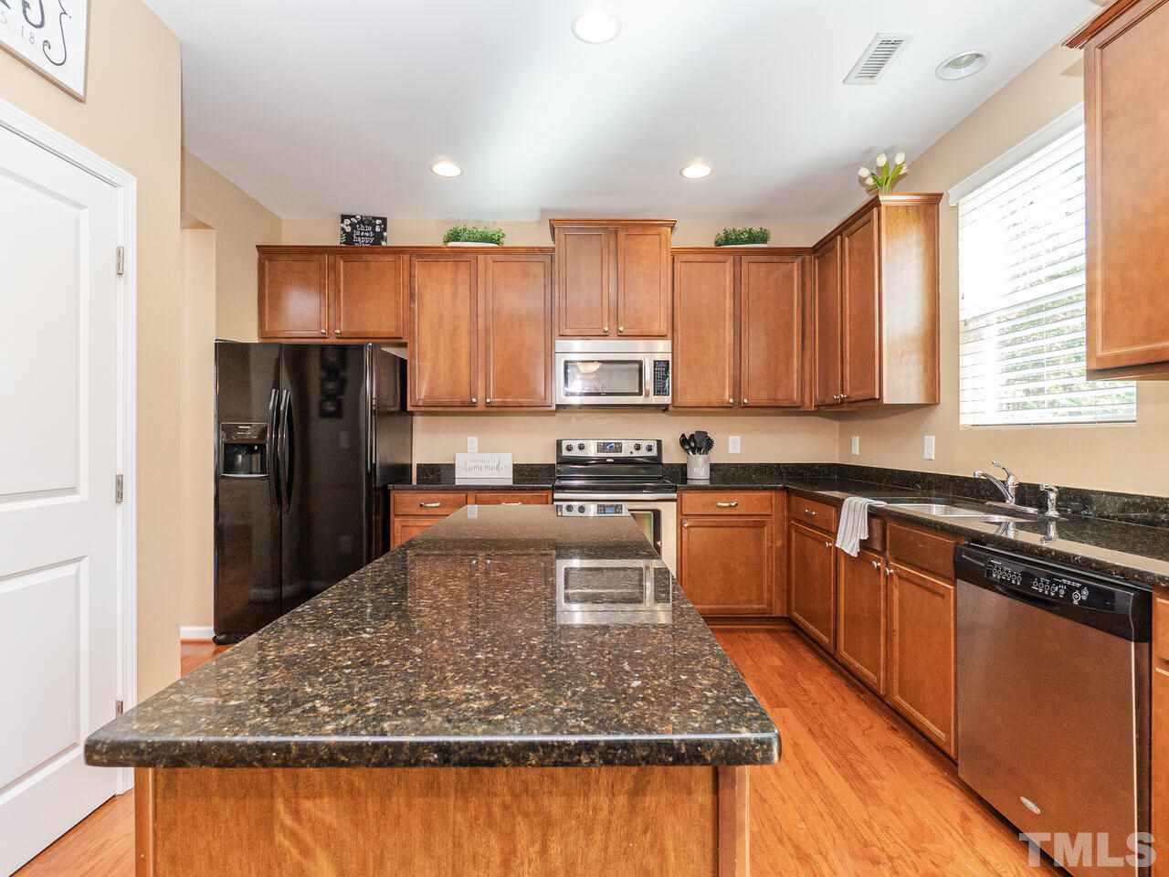 204 Hope Valley Road Knightdale, NC 27545 - Photo 8 of 30 a kitchen with stainless steel appliances granite countertop a refrigerator a stove and a sink