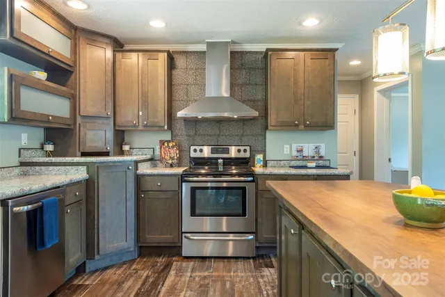 a kitchen with stainless steel appliances granite countertop a stove a sink and a refrigerator