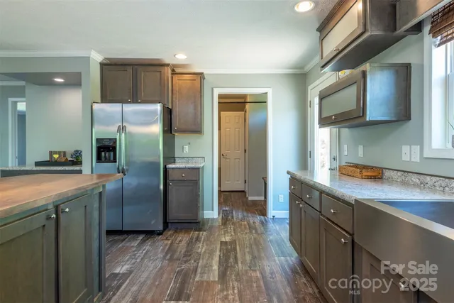 a kitchen with stainless steel appliances granite countertop a refrigerator a sink and wooden cabinets