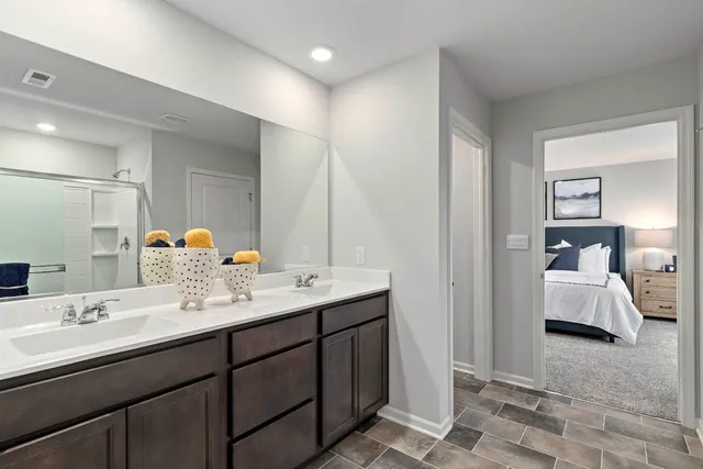 a en suite bathroom with a double vanity sink and mirror