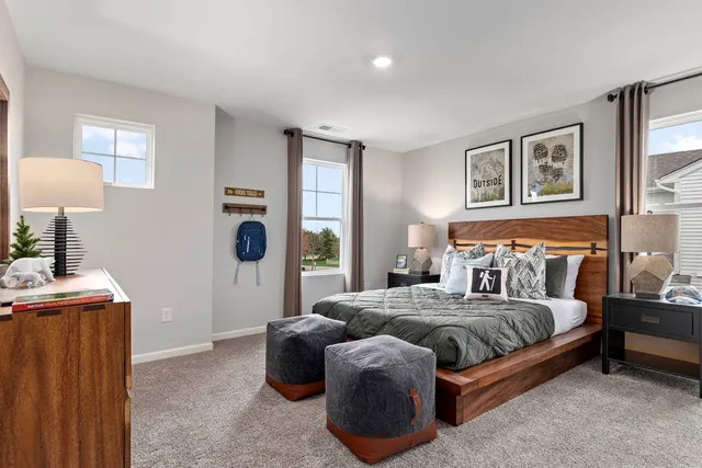 a bedroom with a bed and a lamp on dresser