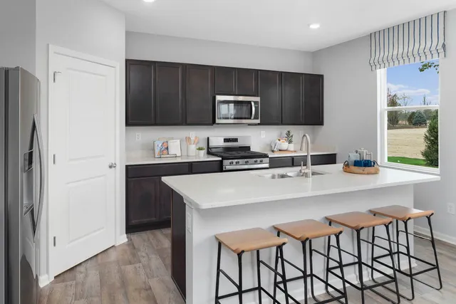 a kitchen with stainless steel appliances a microwave a sink and cabinets