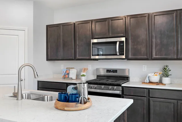 a kitchen with a sink a microwave and cabinets