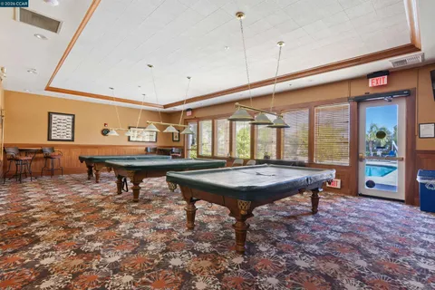 a room with furniture pool table and windows