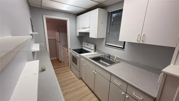 a kitchen with a sink a stove and cabinets