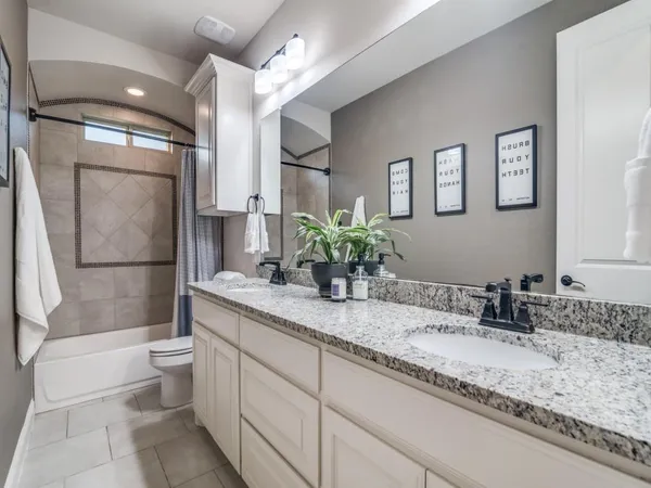 a bathroom with a granite countertop sink a toilet and a shower