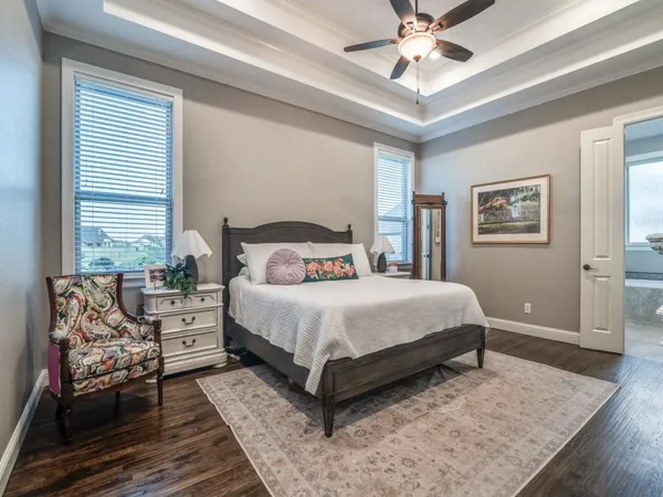 a bedroom with a large bed and a chandelier