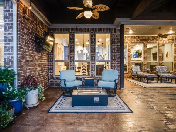 a living room with furniture floor to ceiling window and potted plants