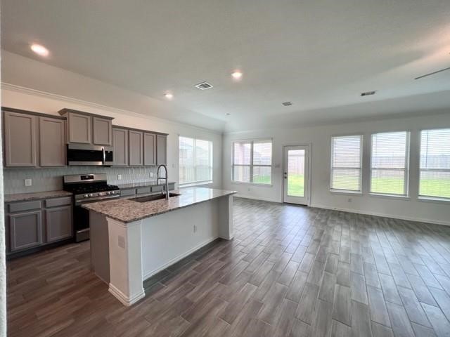 4826 Albany Ridge Lane Rosharon, TX 77583 - Photo 13 of 37 a large kitchen with stainless steel appliances granite countertop a stove a sink dishwasher a microwave oven and a wooden floors