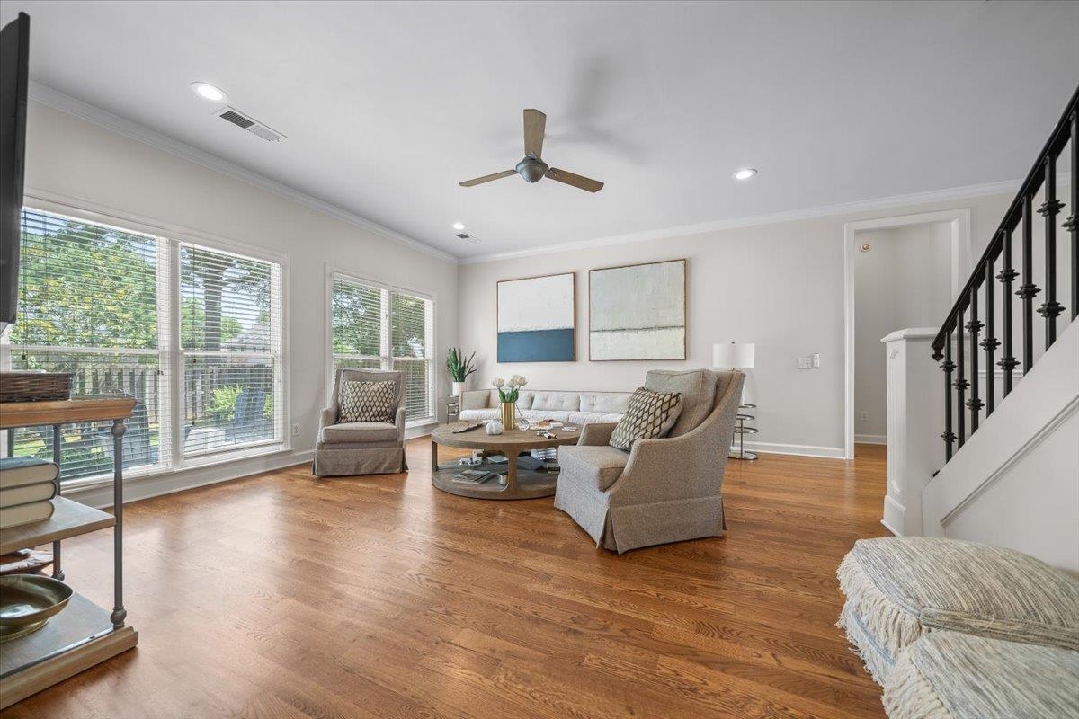 1876 Liles Lane Collierville, TN 38017 - Photo 11 of 36 Spacious living area featuring large windows with blinds, wood-finish flooring, recessed lighting, a ceiling fan, and a staircase with black metal balusters