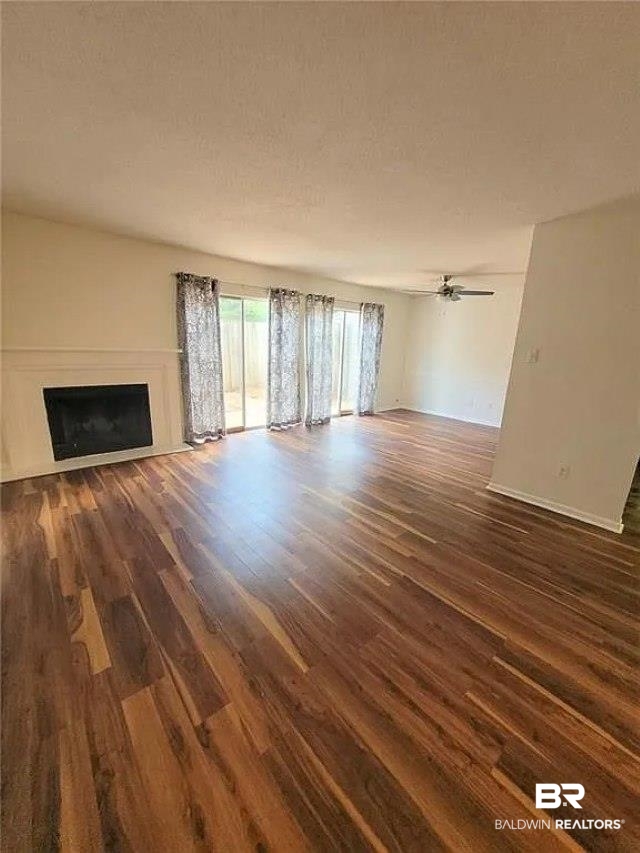 6701 Dickens Ferry Road, Unit 53 Mobile, AL 36608 - Photo 11 of 23 Unfurnished living room featuring a fireplace and dark wood-type flooring