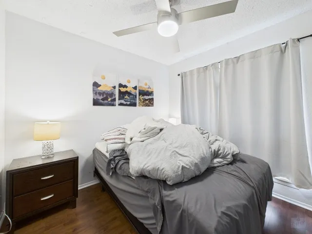 a bed sitting in a bedroom next to a window and a cabinet