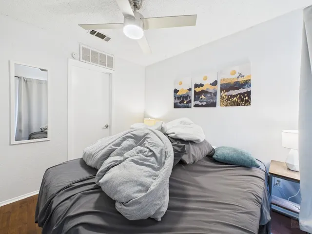 a bedroom with a bed and a painting on the wall
