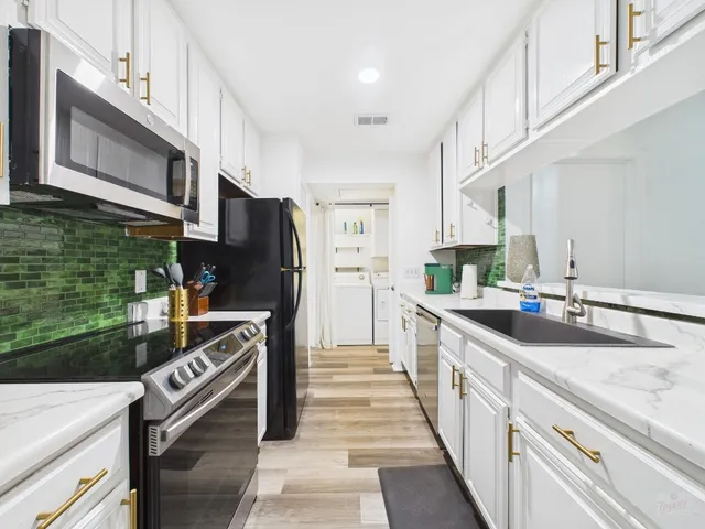 a kitchen with stainless steel appliances granite countertop a sink and a stove