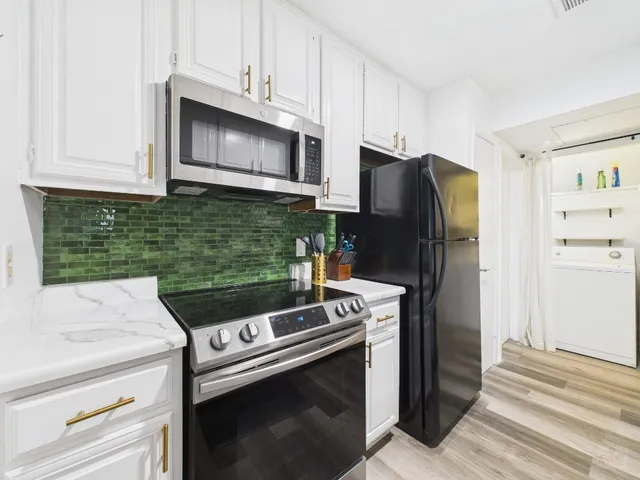 a kitchen with stainless steel appliances granite countertop a refrigerator stove and microwave