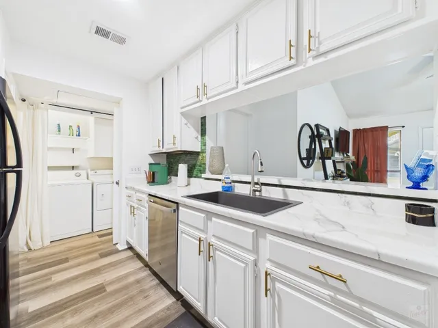 a kitchen with stainless steel appliances granite countertop a sink and a refrigerator