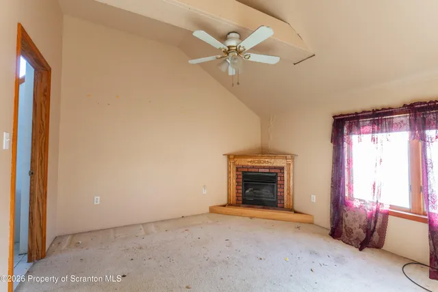 an empty room with fan and windows