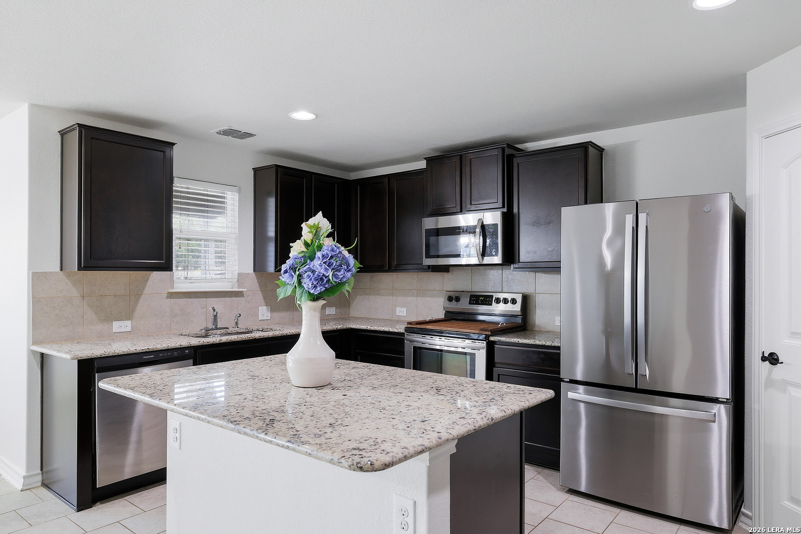 7435 Rigel Chase San Antonio, TX 78252 - Photo 20 of 38 a kitchen with kitchen island a counter space and refrigerator