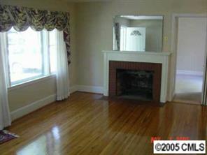 1210 Norland Road Charlotte, NC 28205 - Photo 2 of 8 a view of an empty room with wooden floor and a fireplace