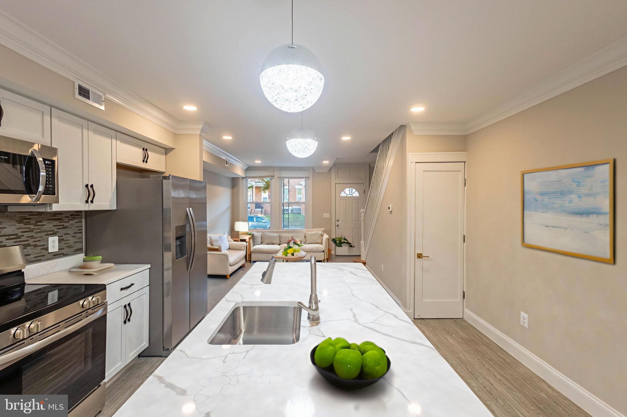2846 Lake Avenue Baltimore, MD 21213 - Photo 2 of 28 a kitchen with stainless steel appliances a dining table chairs and a refrigerator