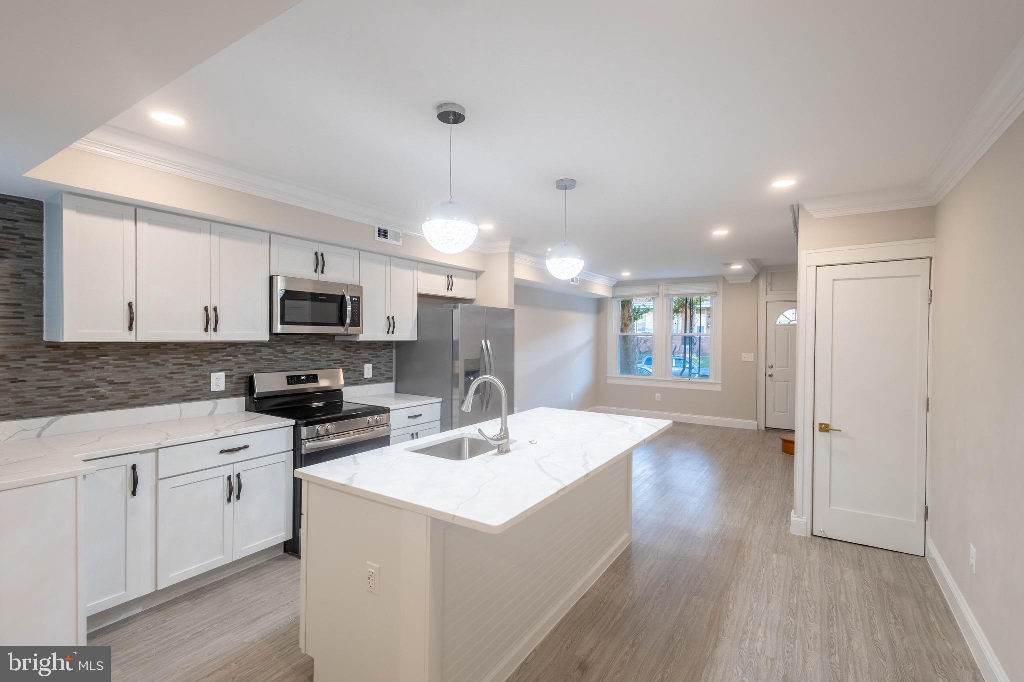 2846 Lake Avenue Baltimore, MD 21213 - Photo 5 of 28 a kitchen with stainless steel appliances a sink a stove a refrigerator and cabinets