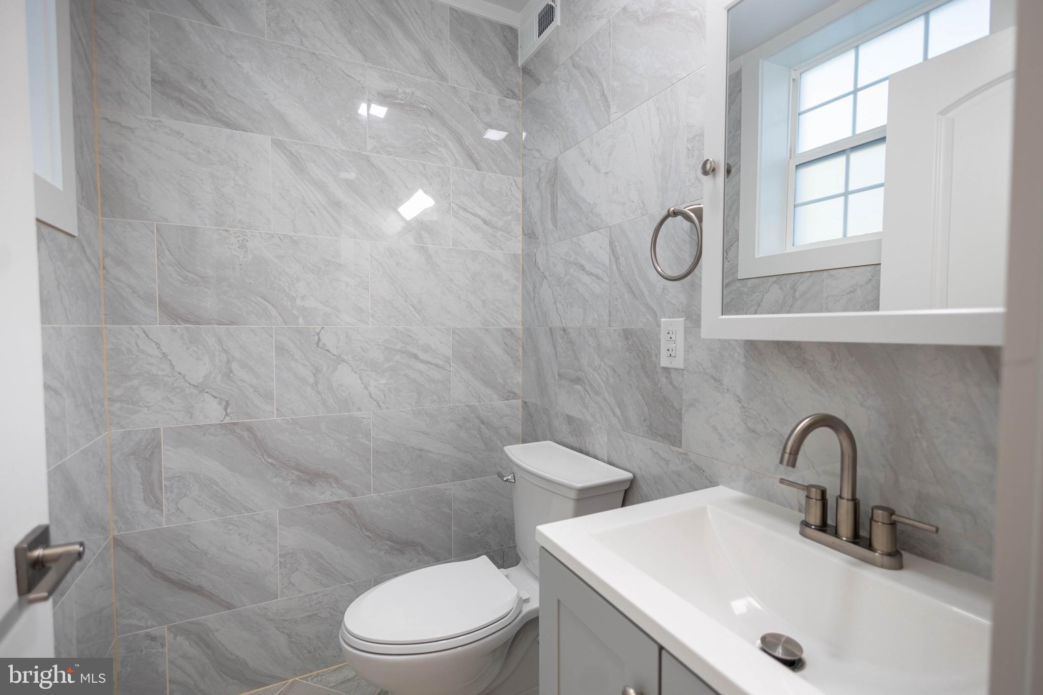 2846 Lake Avenue Baltimore, MD 21213 - Photo 8 of 28 a bathroom with a sink a toilet and shower