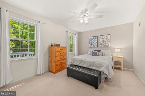 a living room with furniture large windows and flat screen tv