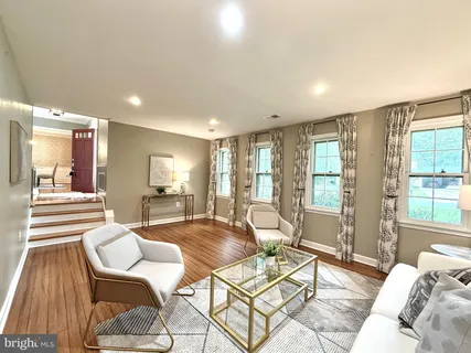 a living room with furniture large window and wooden floor