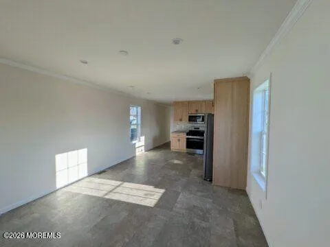 a view of a refrigerator in kitchen and an empty room
