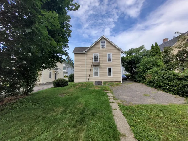 a view of a house with yard and tree s