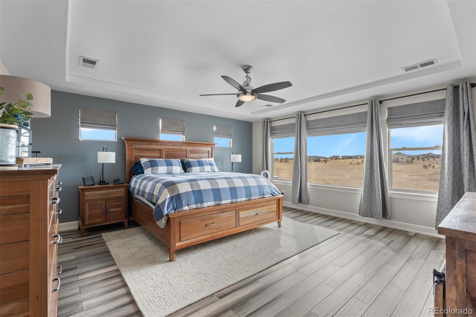 32335 Legacy Ridge Street Elizabeth, CO 80107 - Photo 14 of 50 a bedroom with a bed lamp and a large window with wooden floor