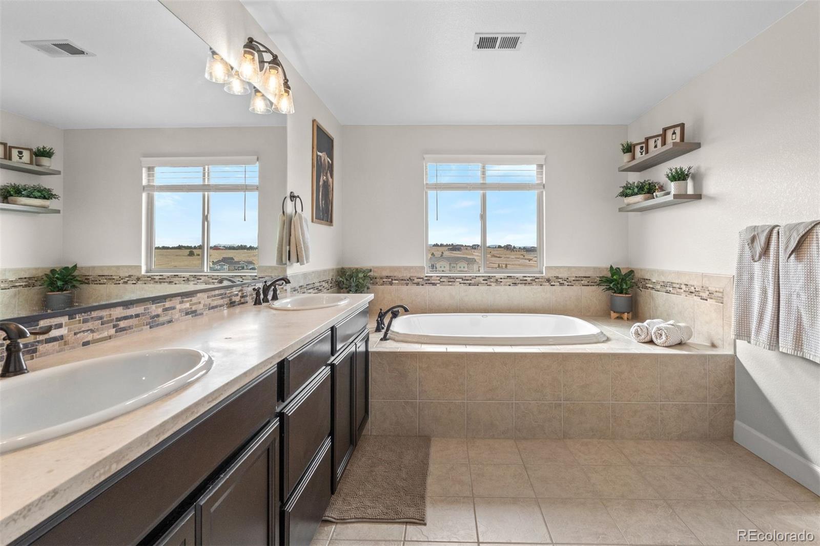 32335 Legacy Ridge Street Elizabeth, CO 80107 - Photo 16 of 50 a spacious bathroom with a bathtub a sink and a window