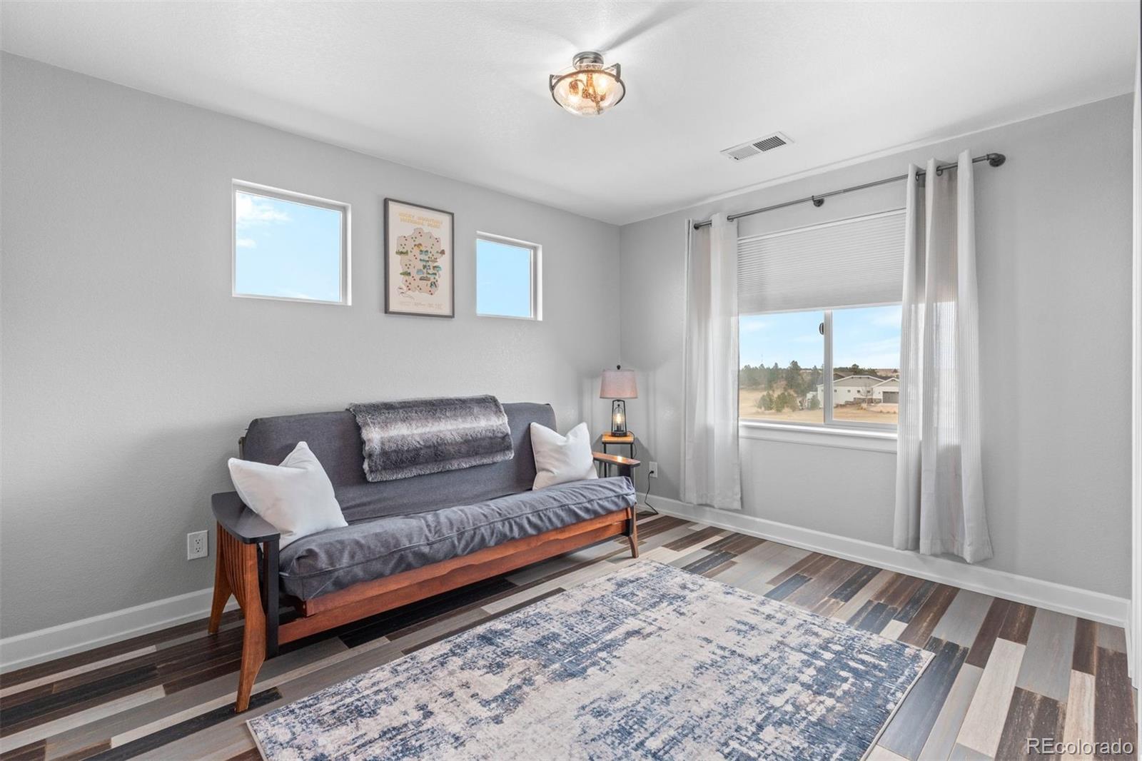 32335 Legacy Ridge Street Elizabeth, CO 80107 - Photo 19 of 50 a living room with a couch and a rug