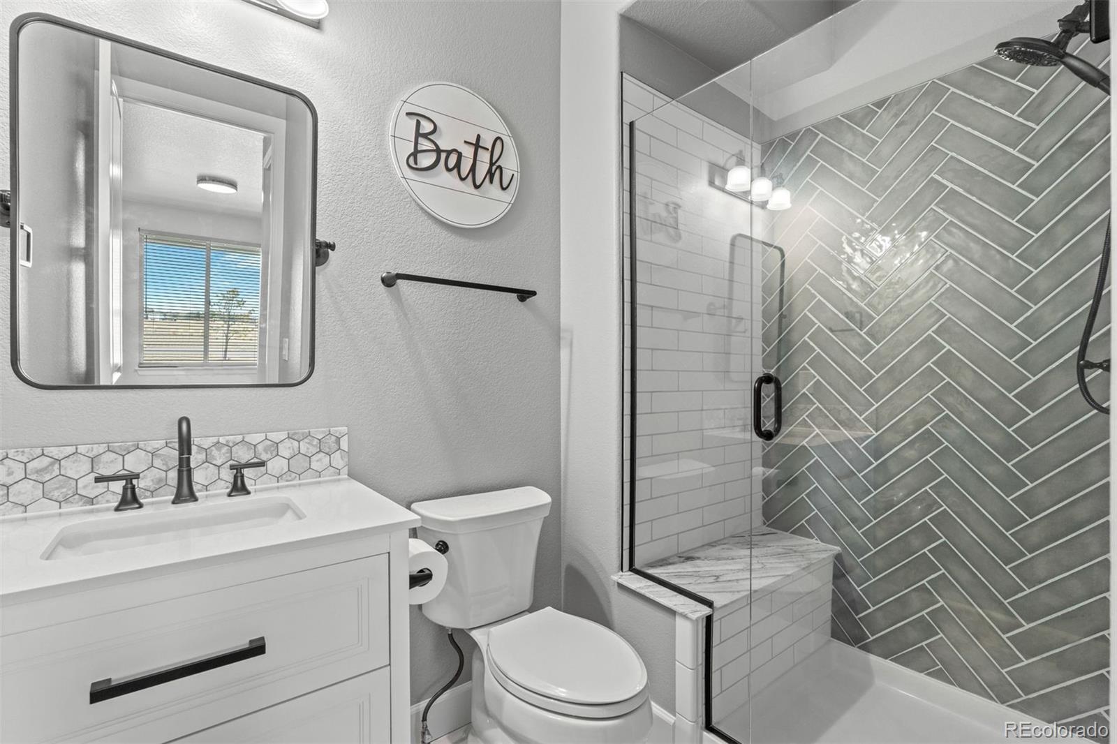 32335 Legacy Ridge Street Elizabeth, CO 80107 - Photo 27 of 50 a bathroom with a toilet sink vanity and mirror