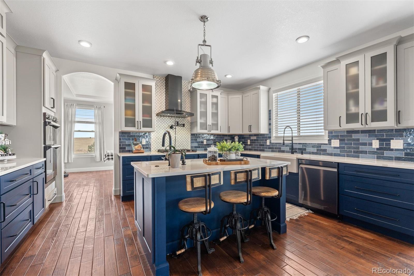 32335 Legacy Ridge Street Elizabeth, CO 80107 - Photo 7 of 50 a kitchen with stainless steel appliances a dining table chairs stove and cabinets