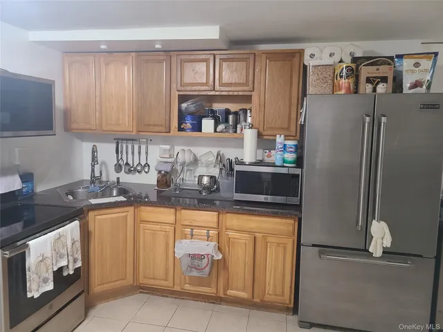 a kitchen with granite countertop a refrigerator stove and sink