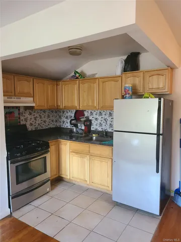 a kitchen with stainless steel appliances granite countertop a refrigerator a stove a sink and a microwave