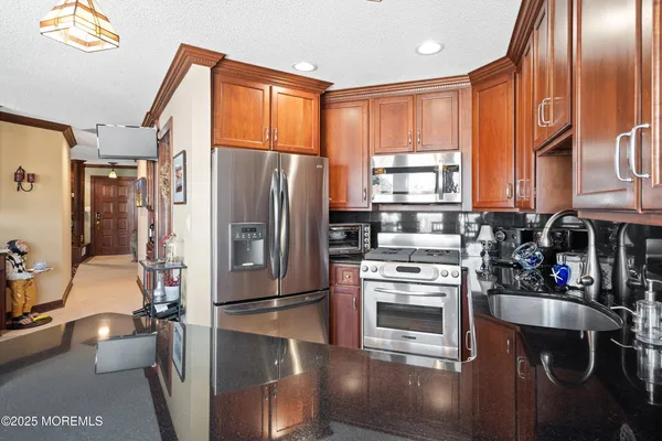 a kitchen with a refrigerator wooden floor and a sink
