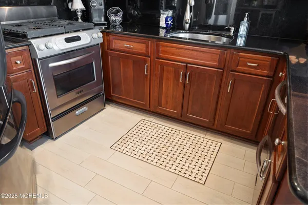 a kitchen with granite countertop a stove top oven and cabinets