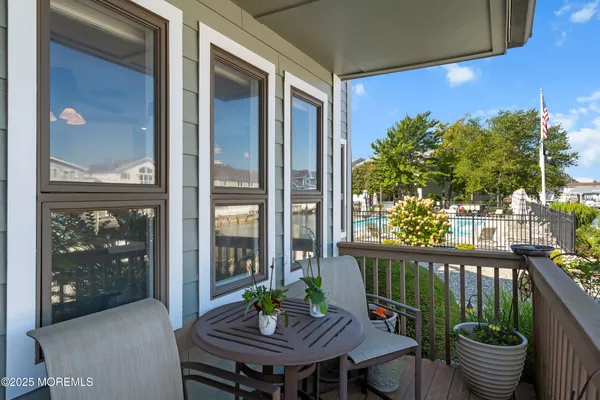 a view of a balcony with chairs and a potted plant