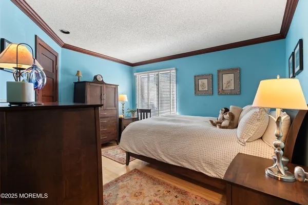 a bedroom with a bed and dresser with mirror