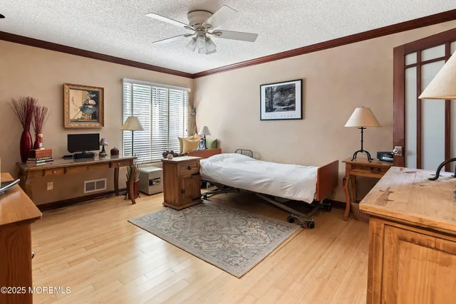 a bedroom with a bed a dresser and potted plant on the dresser