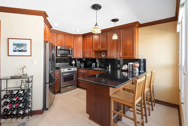 a kitchen with stainless steel appliances kitchen island granite countertop a refrigerator and a stove top oven