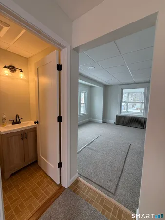 a view of a hallway to a room with window