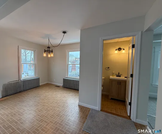 an empty room with windows and cabinet